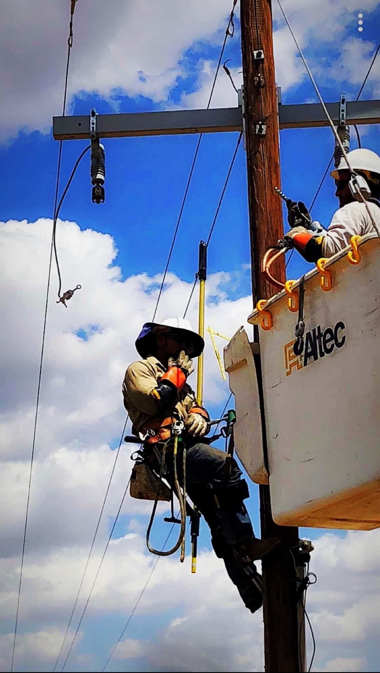 Johnny Garcia and a fellow lineman performing maintenance on overhead power lines