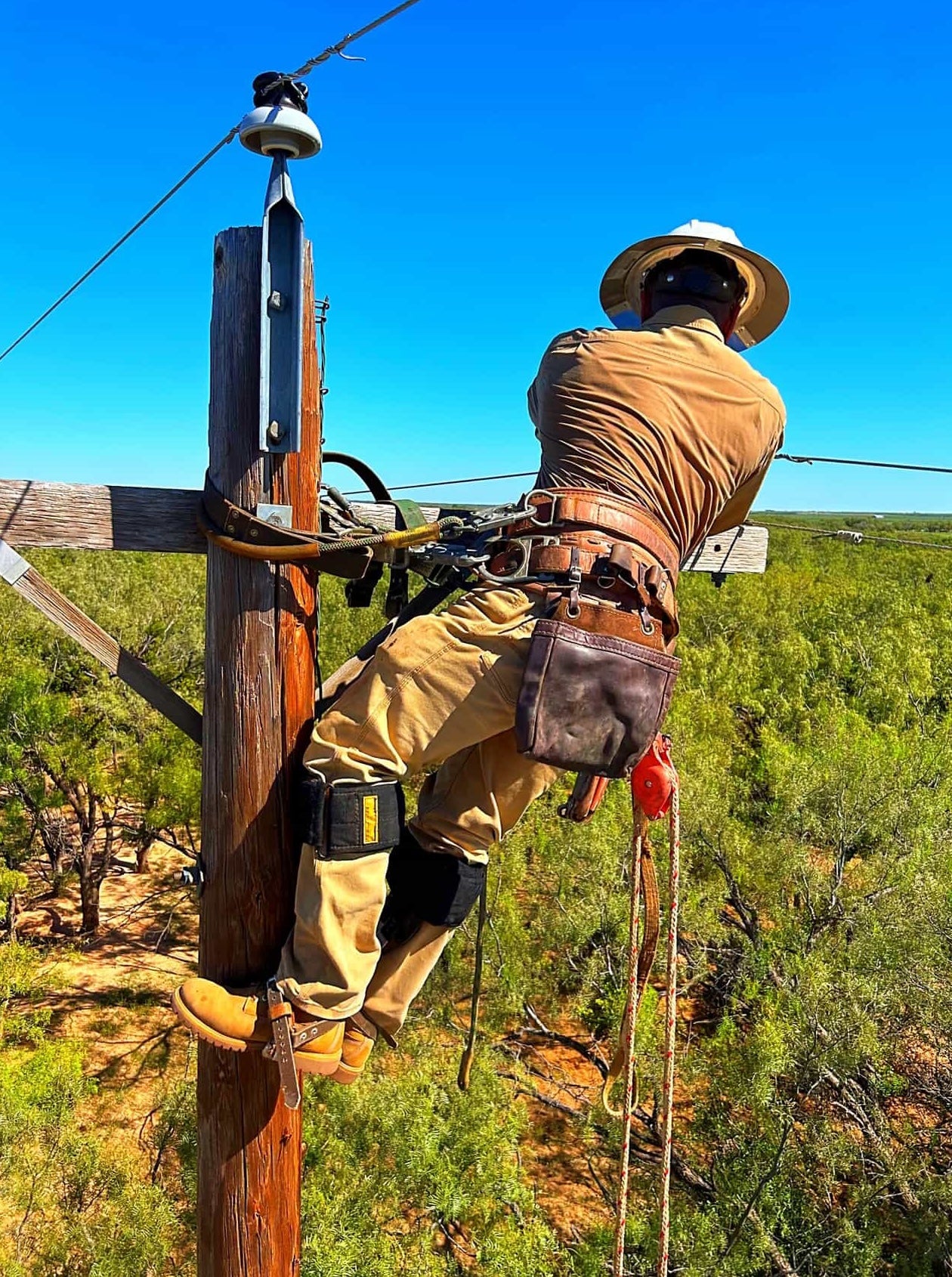 Johnny Garcia and a fellow lineman performing maintenance on overhead power lines