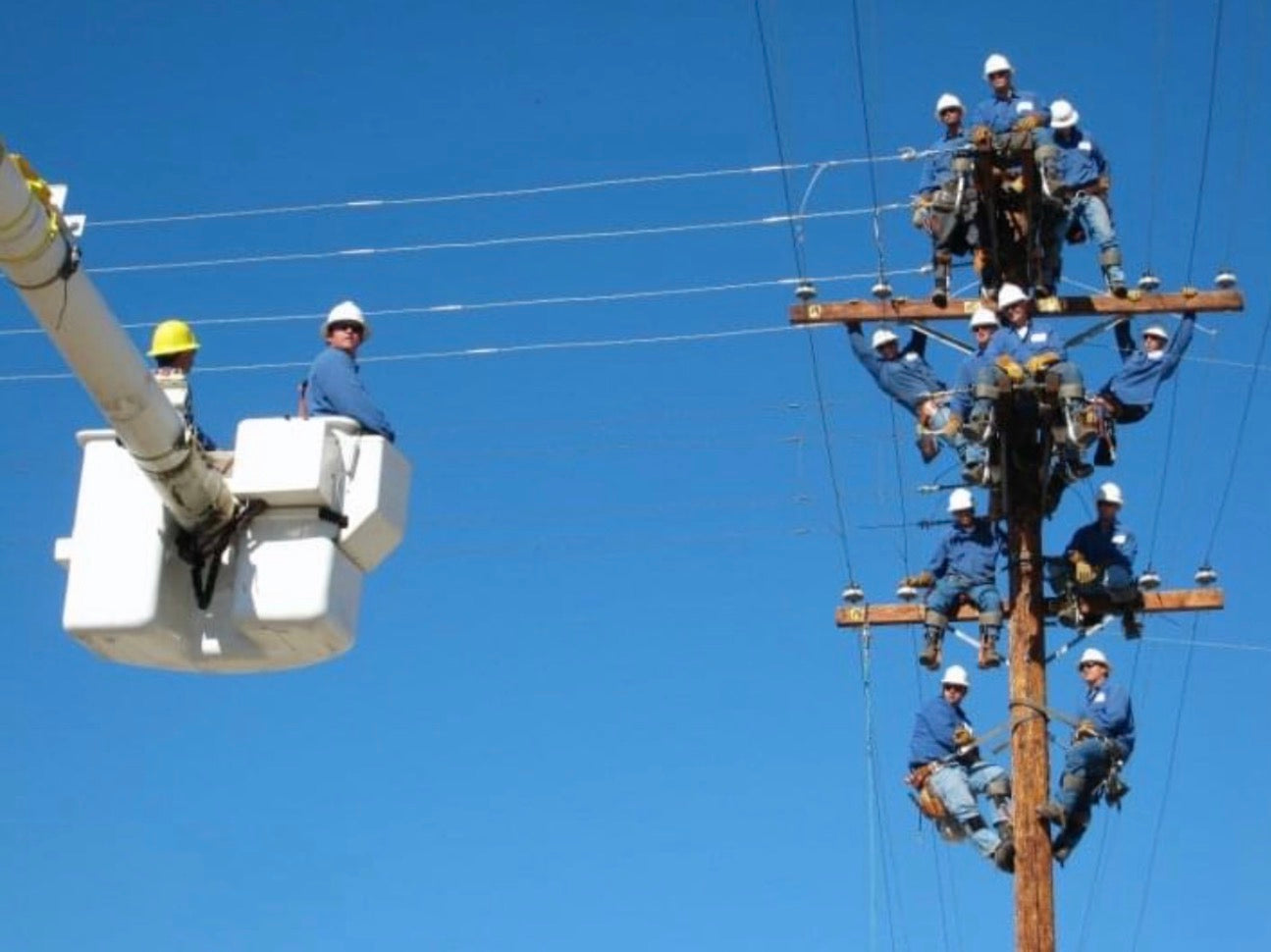 Jude Jolma and crew working on high-voltage lines, securing equipment and performing maintenance while suspended on the pole