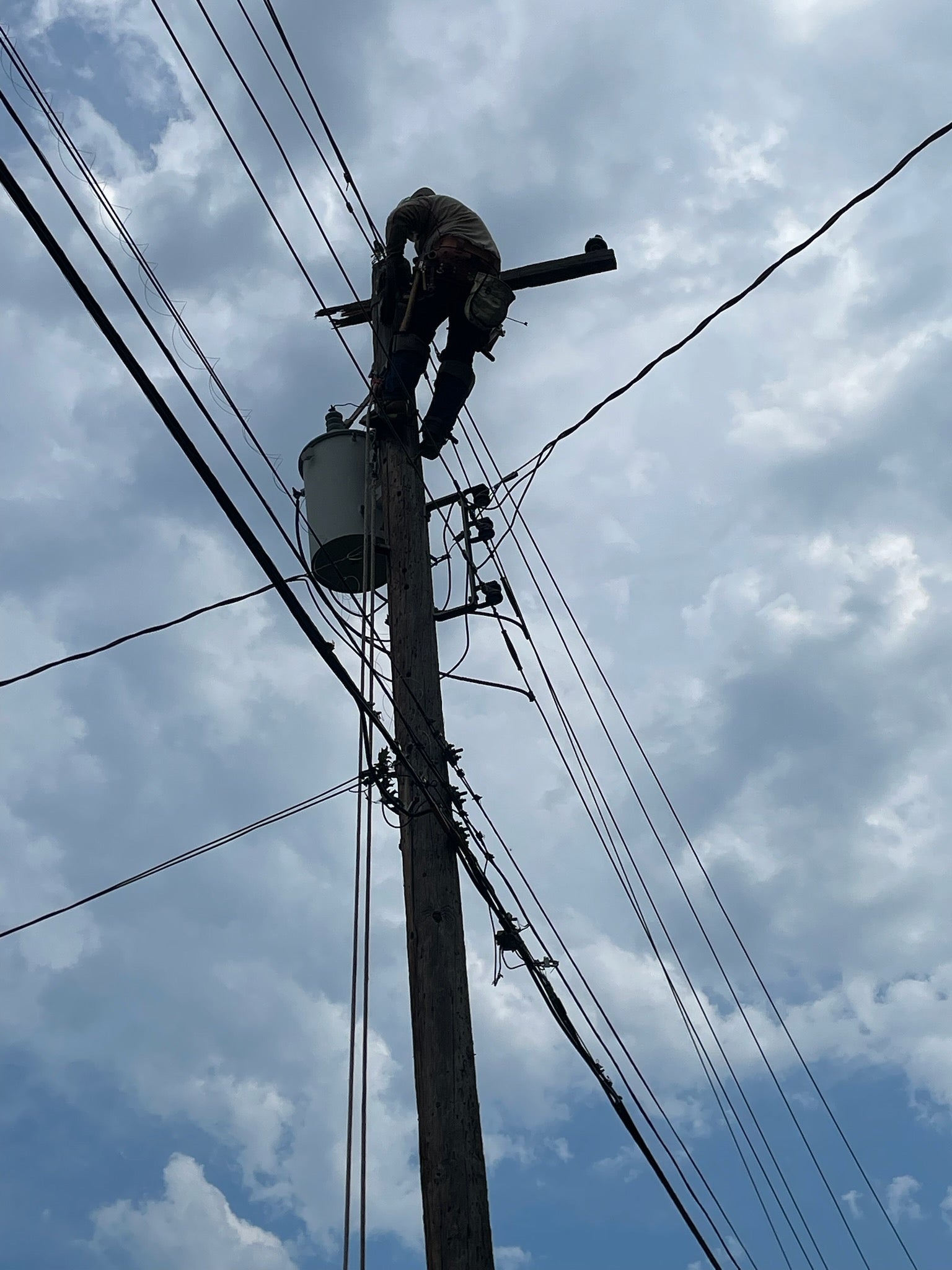 Jude Jolma sitting in an office wearing a beige electrical company shirt and cap