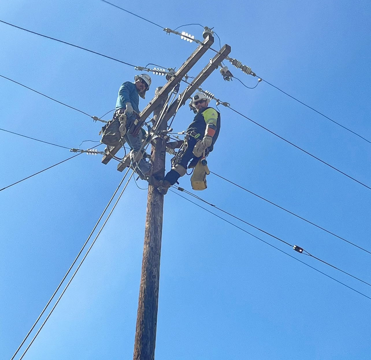 Johnny Garcia and a fellow lineman performing maintenance on overhead power lines