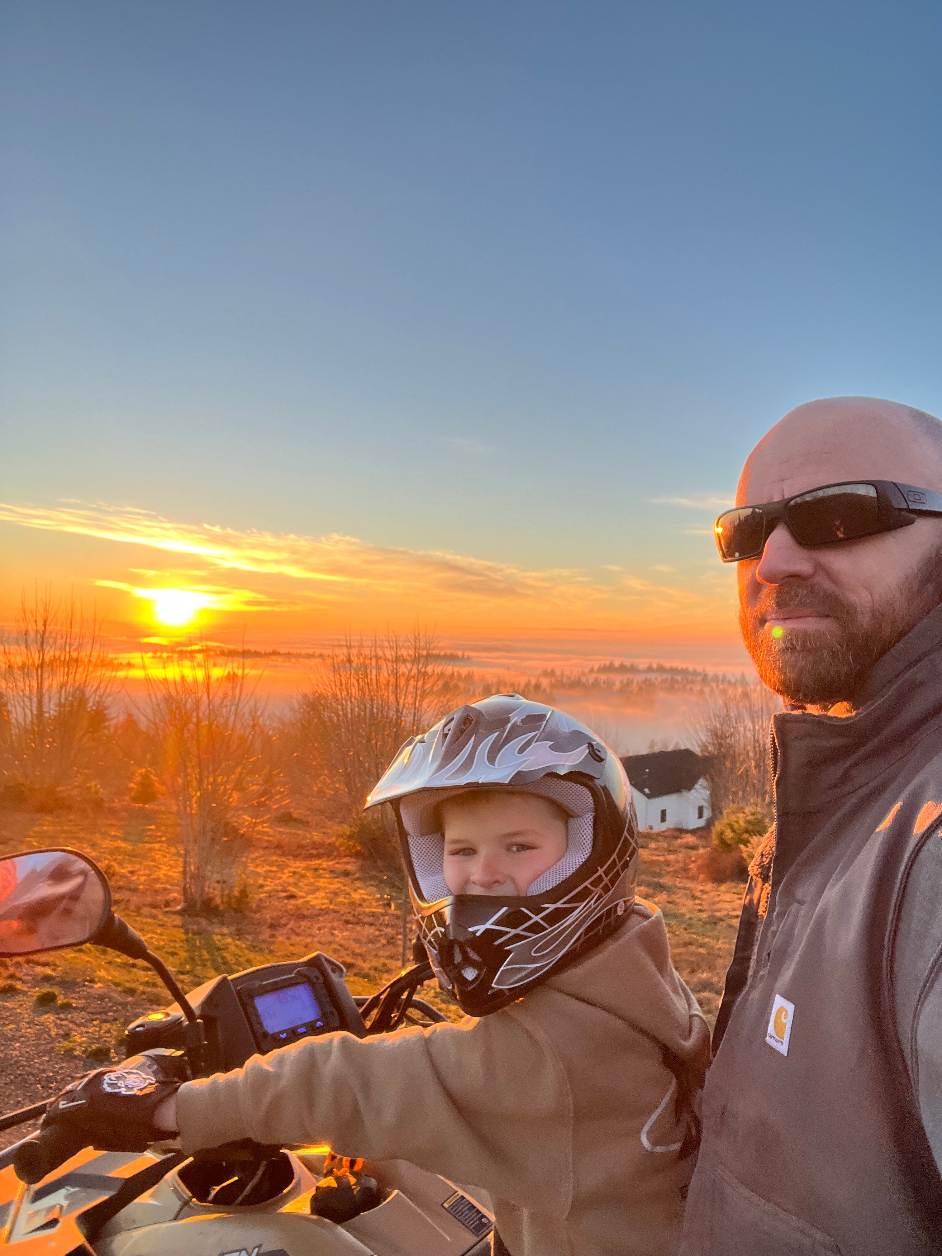 Jude Jolma riding an ATV with his son at sunrise