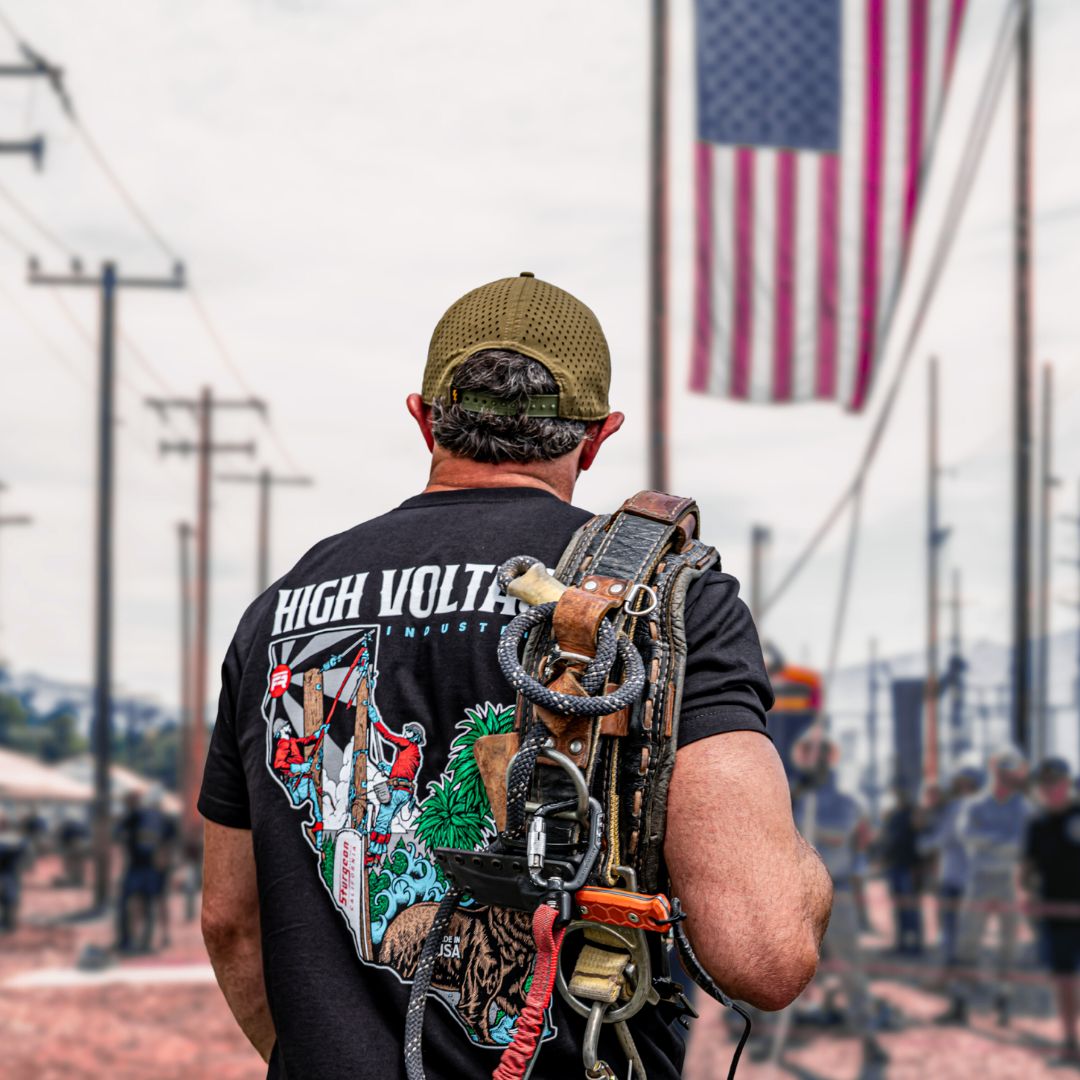 A tradesman facing the poles during a lineman rodeo