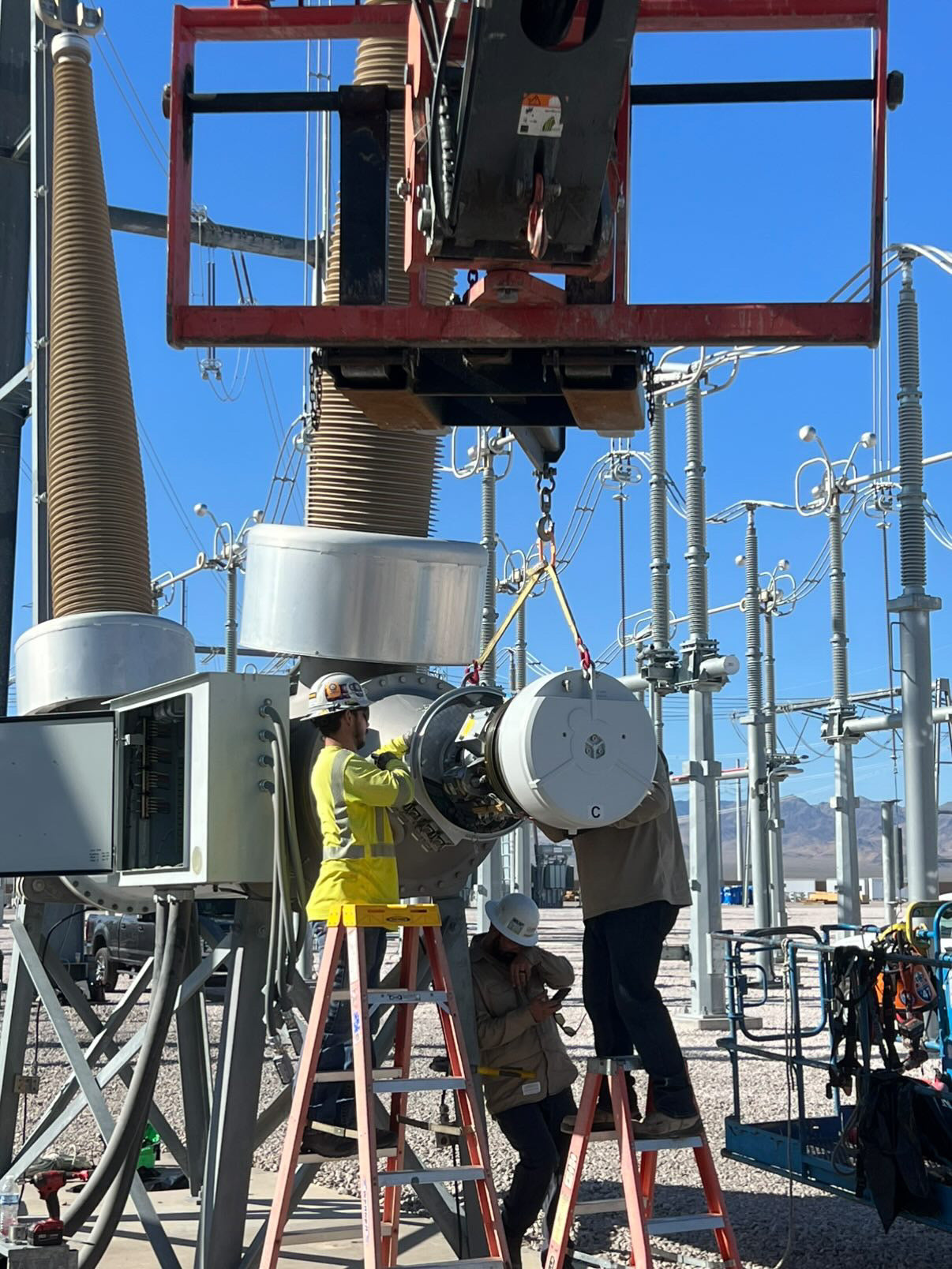 Substation electrician installing high-voltage circuit breaker equipment at an electrical substation