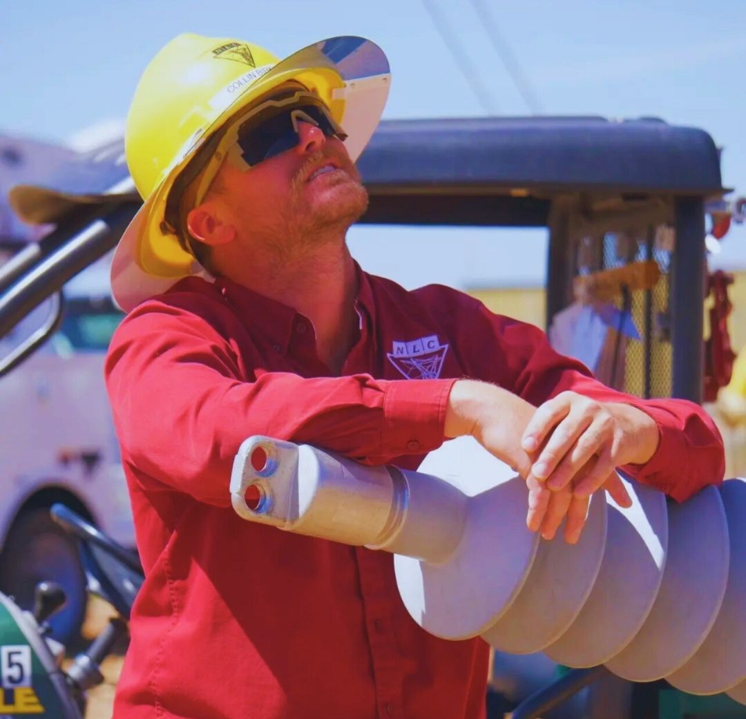 Collin Birkholz with a hard hat and NLC long sleeves looking up