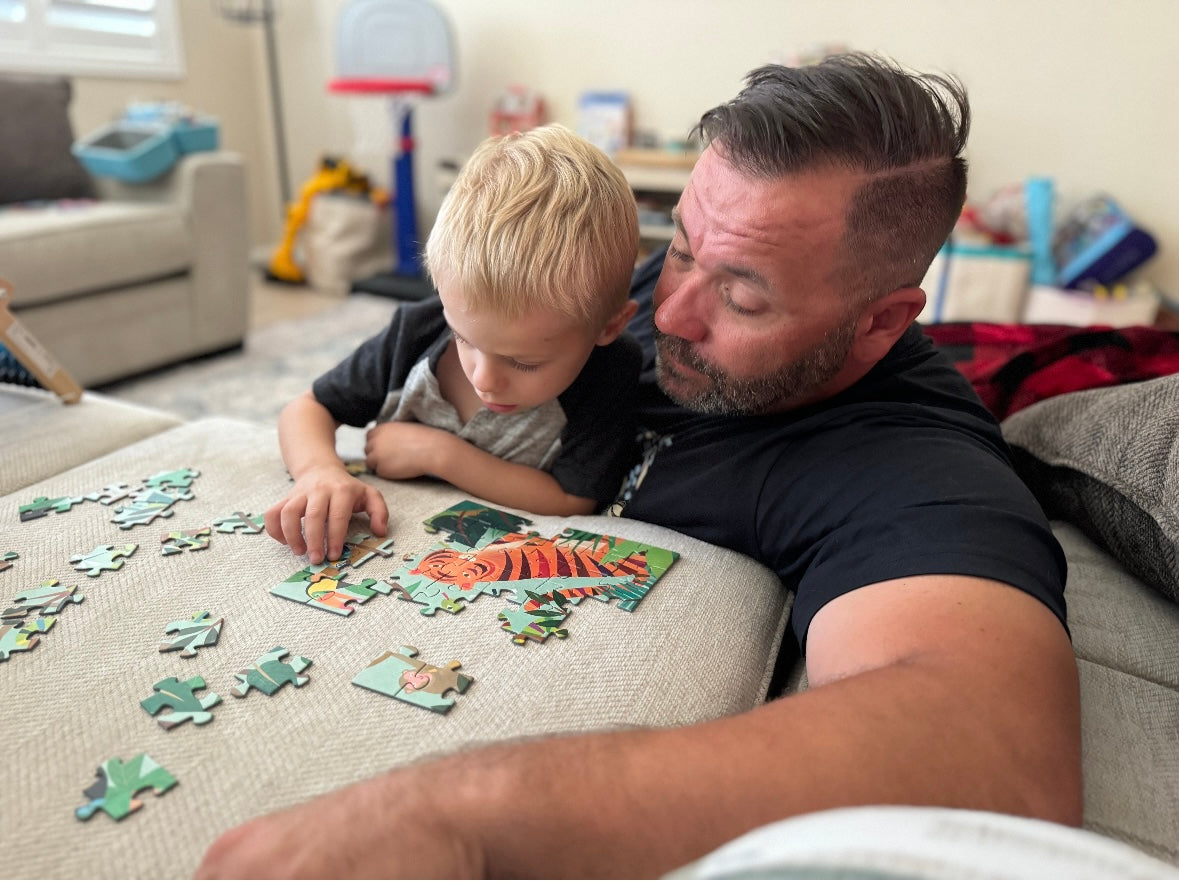 Sammy Micco spending quality time with his son, working together on a puzzle at home.
