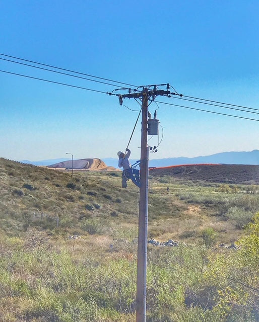 Jude Jolma smiling with his daughter at a community lineman event
