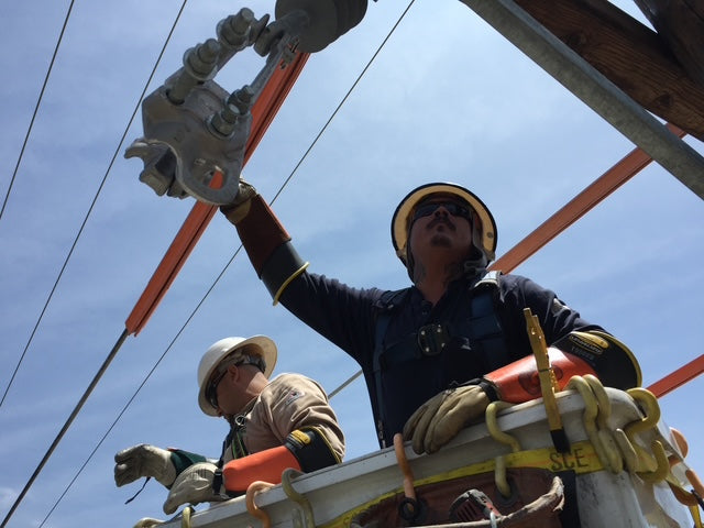 Jude Jolma sitting in an office wearing a beige electrical company shirt and cap