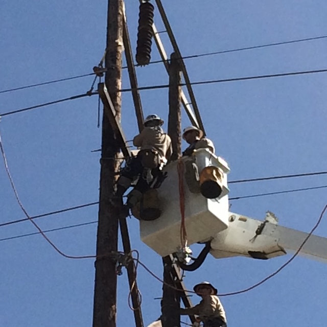 Jude Jolma smiling with his daughter at a community lineman event
