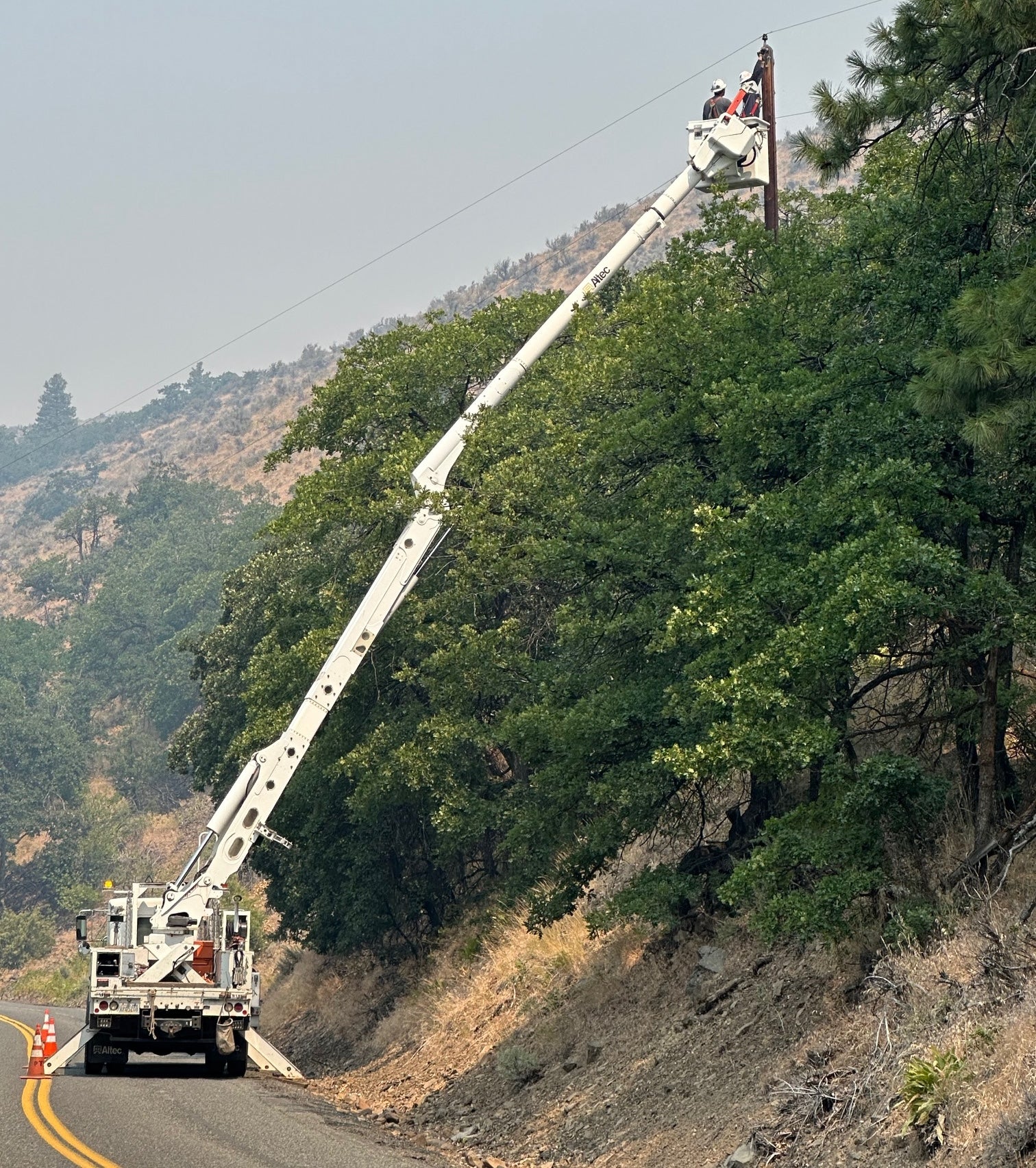 Jude Jolma sitting in an office wearing a beige electrical company shirt and cap