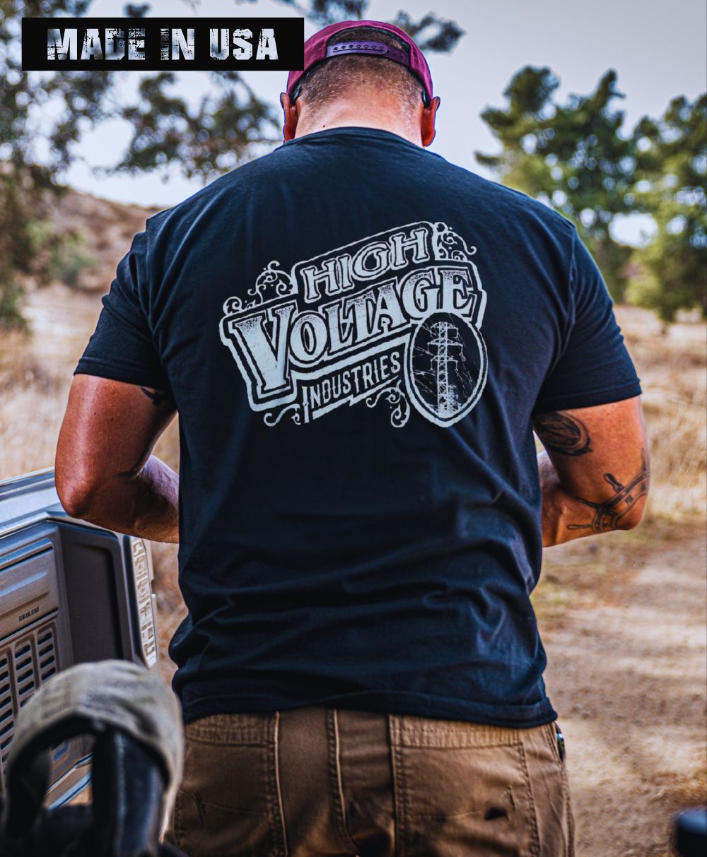 Man wearing a black High Voltage Vintage Logo t-shirt outdoors.