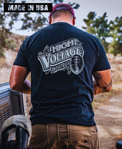 Man wearing a black High Voltage Vintage Logo t-shirt outdoors.